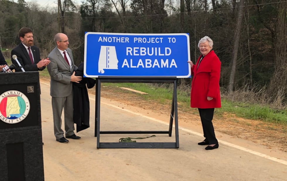 La gobernadora Kay Ivey posa junto a un letrero de «Rebuild Alabama» tras una conferencia de...