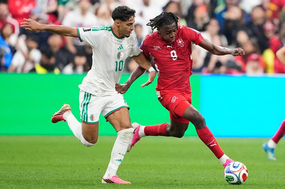 Johan Manzambi, de la selección de Suiza, conduce un balón frente a Fares Chaibi, de Argelia,...