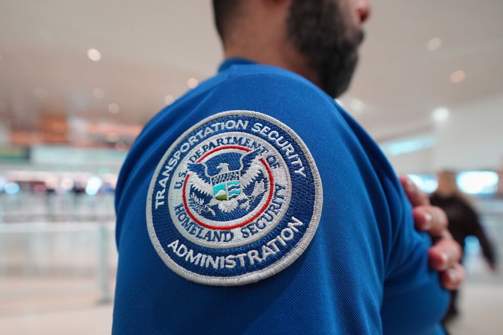 Un agente de la TSA con un parche del Departamento de Seguridad Nacional en su uniforme en el...