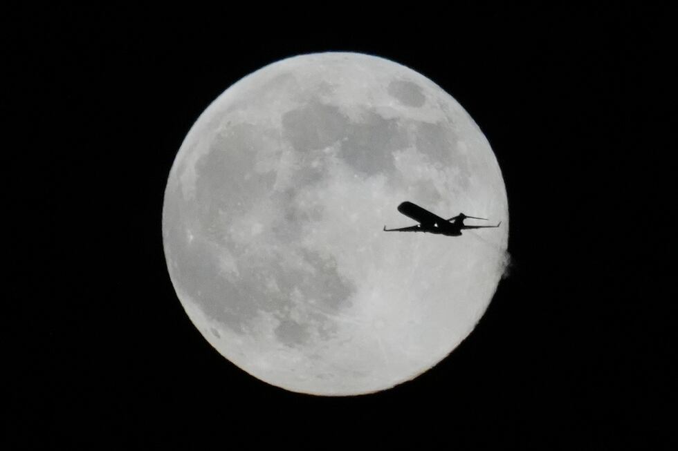 Un avión vuela frente a una Superluna, el jueves 4 de diciembre de 2025 en Chicago. (AP...