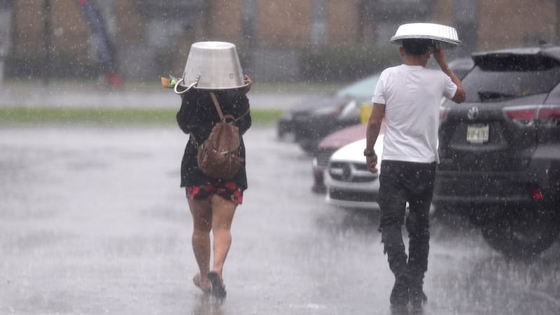 La gente se protege de un torrencial aguacero en Dallas el 24 de diciembre del 2024. (AP...
