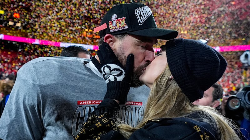 El tight end de los Chiefs de Kansas City, Travis Kelce, y Taylor Swift se besan tras el...